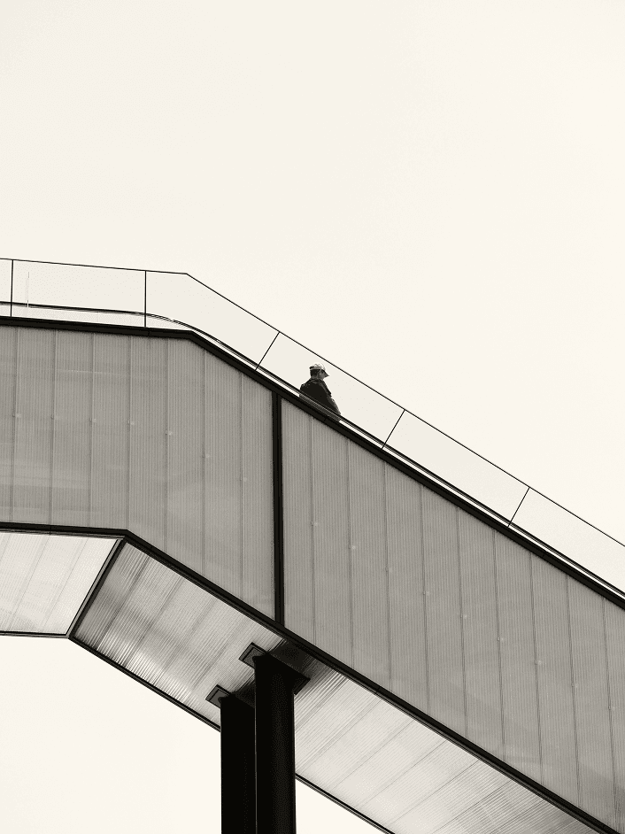 A man goes down the escalator alone. He looks lonely. Don't be like him.